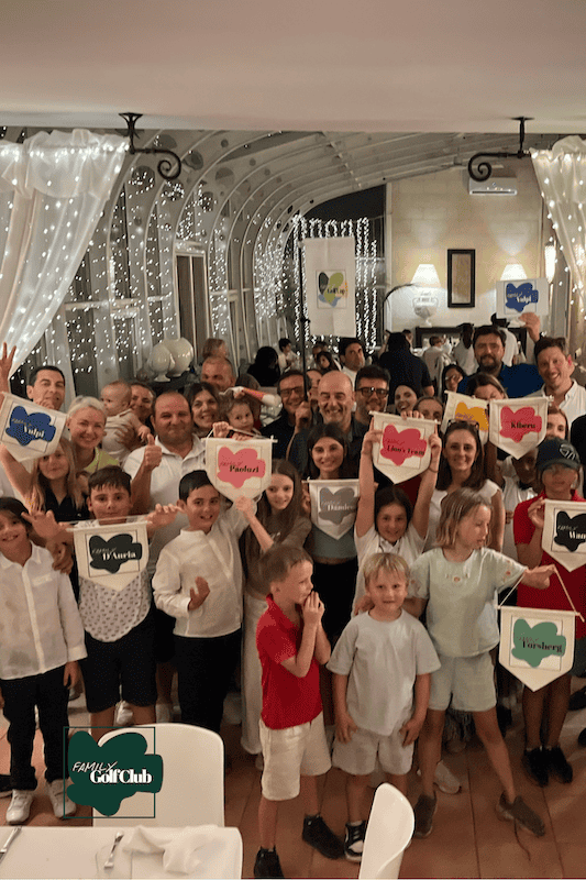 Group of children and adults celebrating at Family Golf Club event.